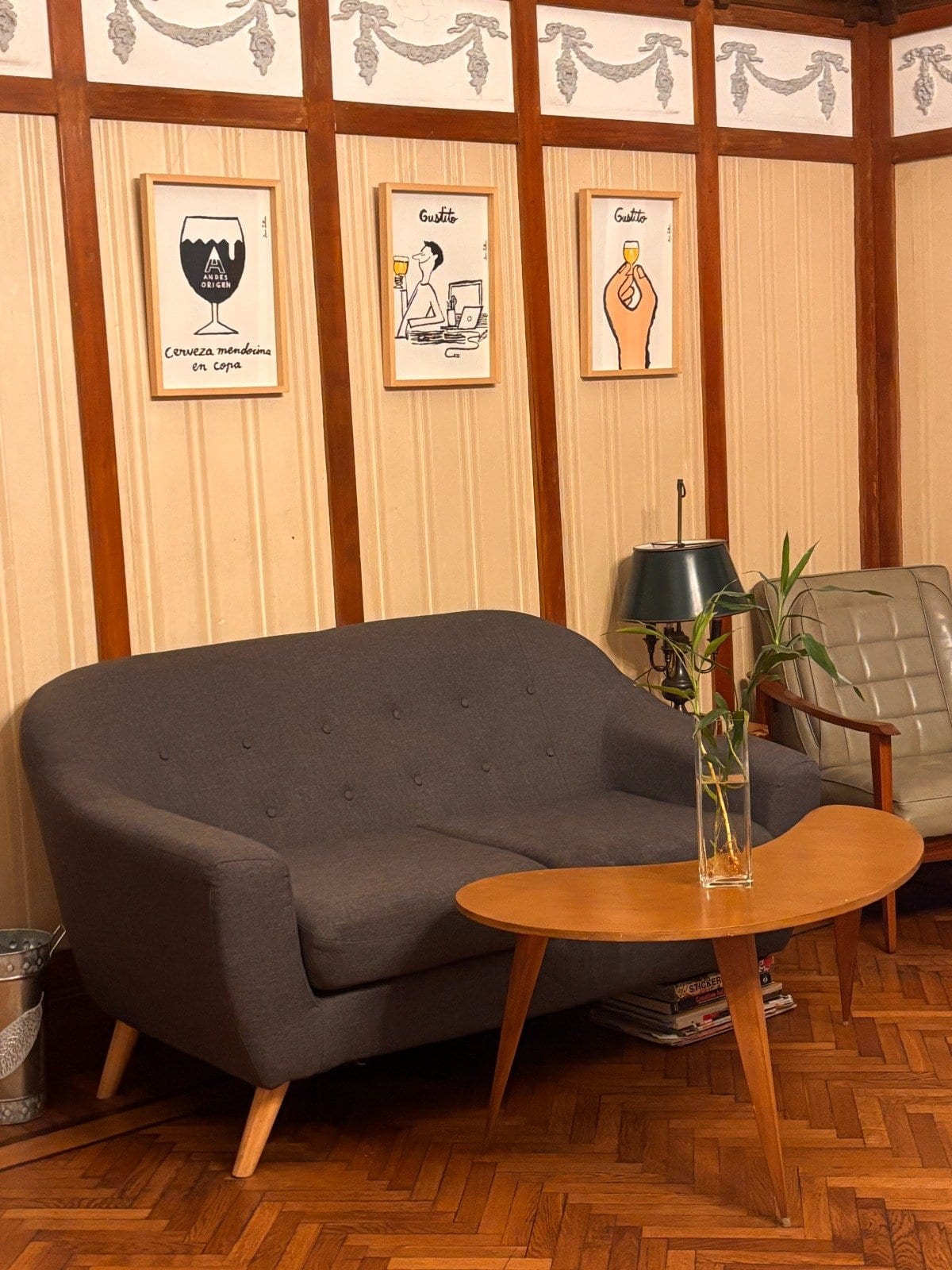 Living de la entrada con sofá retro, cuadros enmarcados y boiserie original — el espacio común de Pawer Belgrano