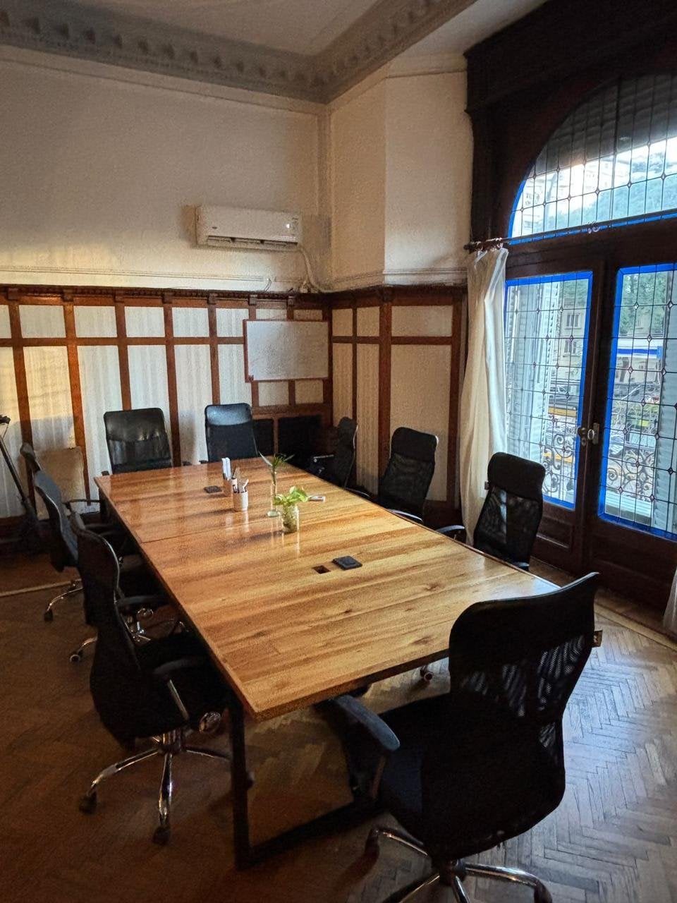 Oficina privada Cabildo Norte en Pawer Belgrano: vitrales originales con vidrios azules, boiserie de madera y mesa para 8 personas con vista a Av. Cabildo